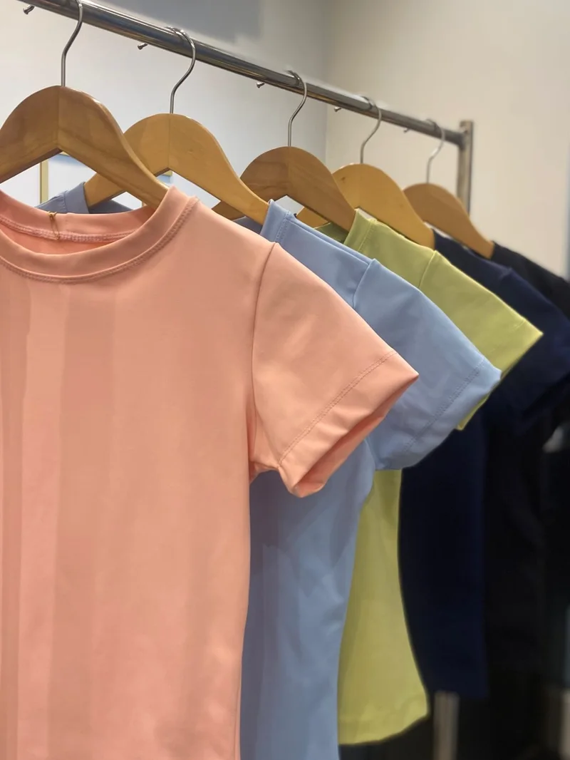 Baby looks em rosa, azul, amarelo e marinho nos cabides da TSfit