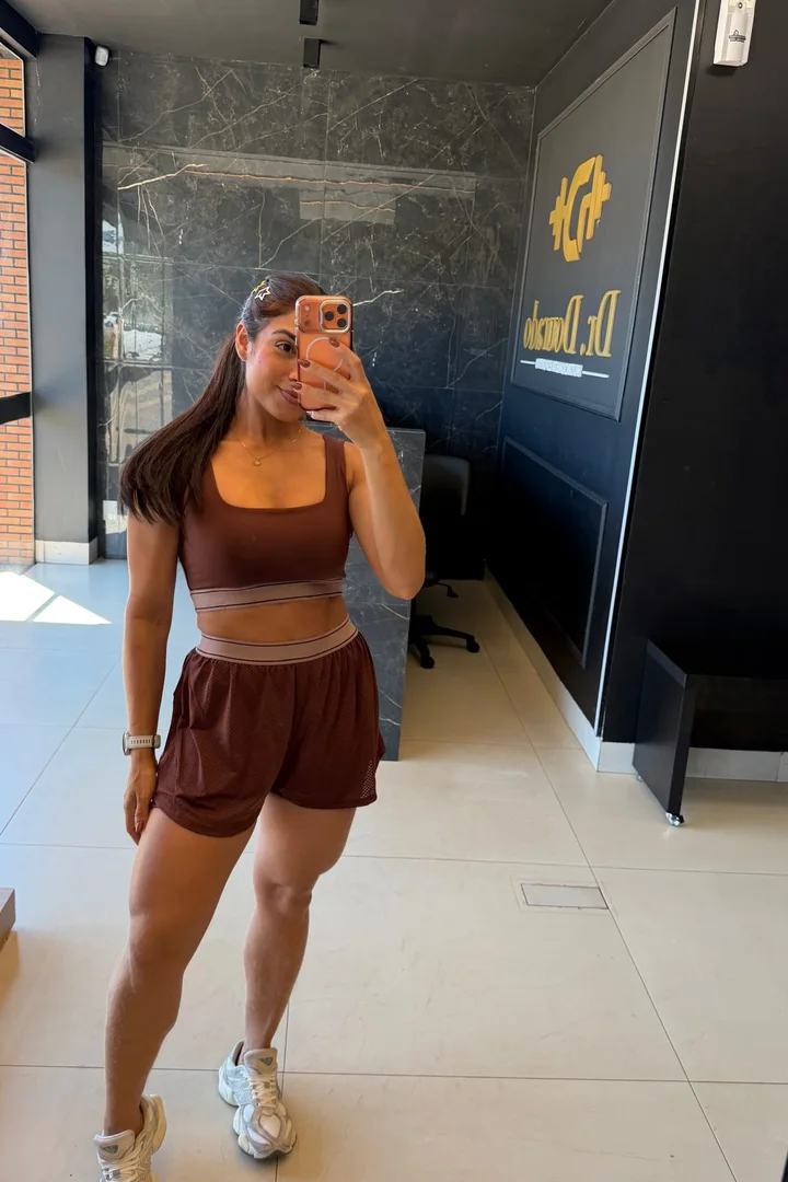 Conjunto Line marrom com top e short duplo, no provador da TSfit