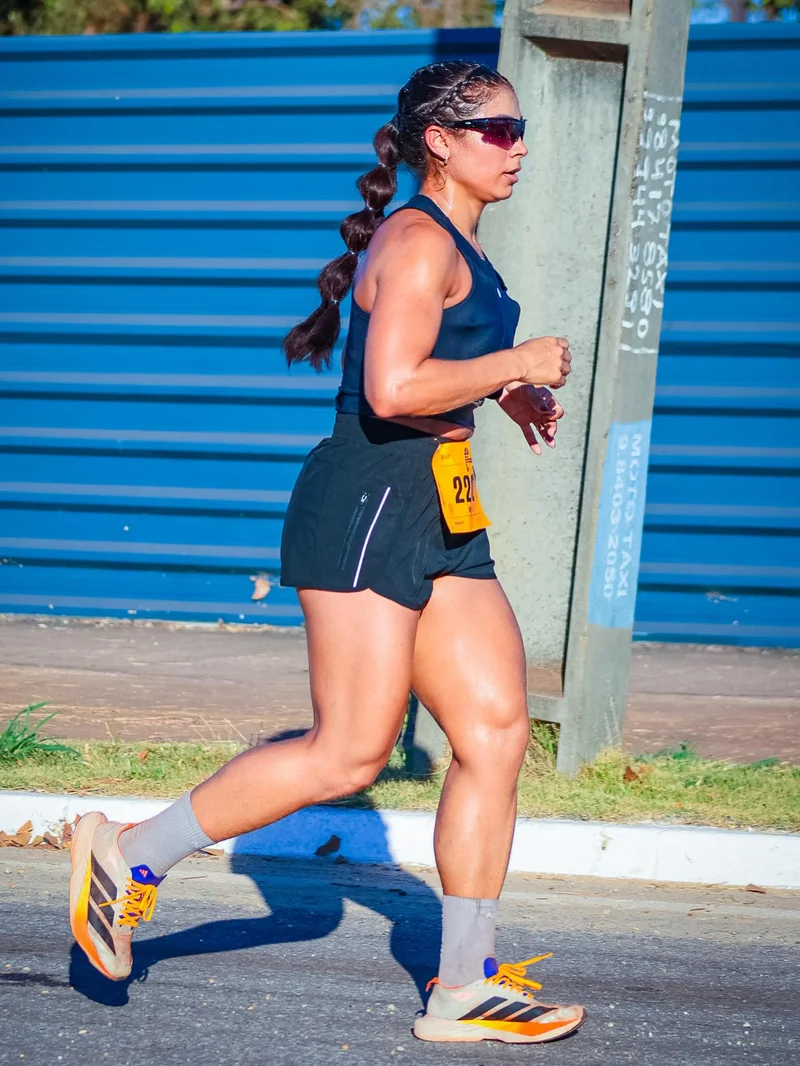 Corredora de regata e short escuros durante a meia maratona
