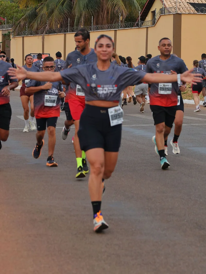 Corredora de braços abertos em prova de rua de 5 km