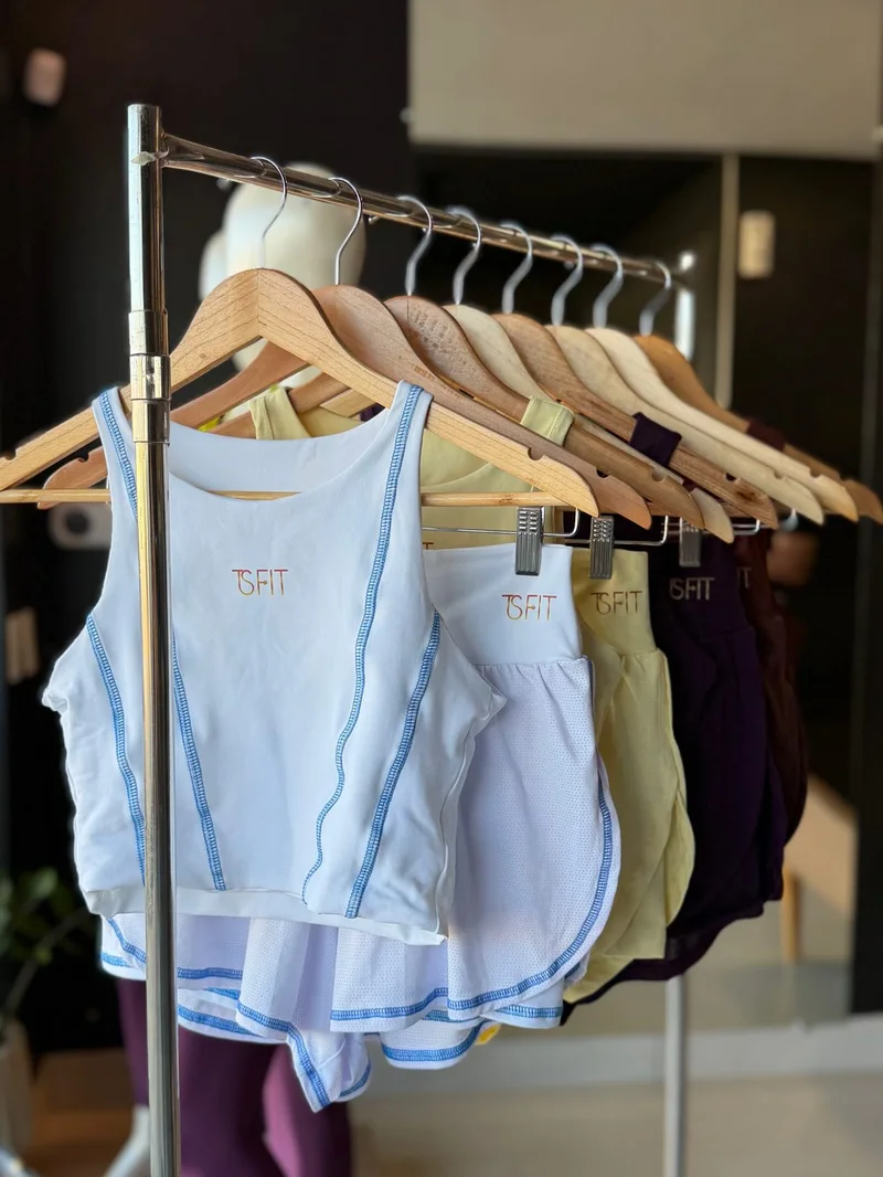 Tops em diferentes cores nos cabides da loja TSfit